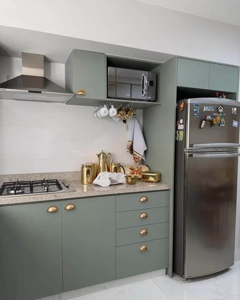 Remodelled kitchen with sage green cabinets, white counters and brass pulls